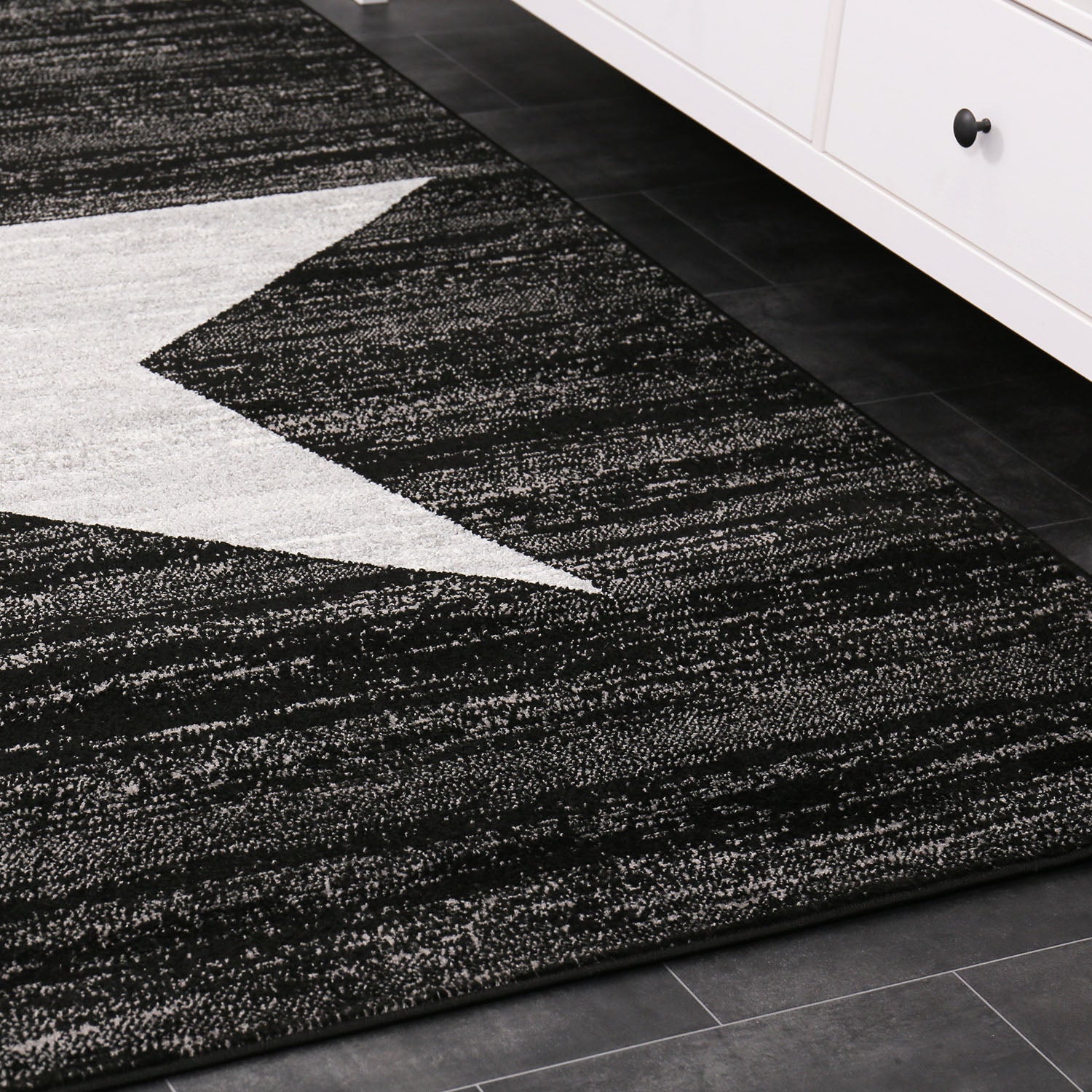 Short-pile rug with a modern star pattern in black, suitable for teenagers' rooms, children's rooms, and living rooms.