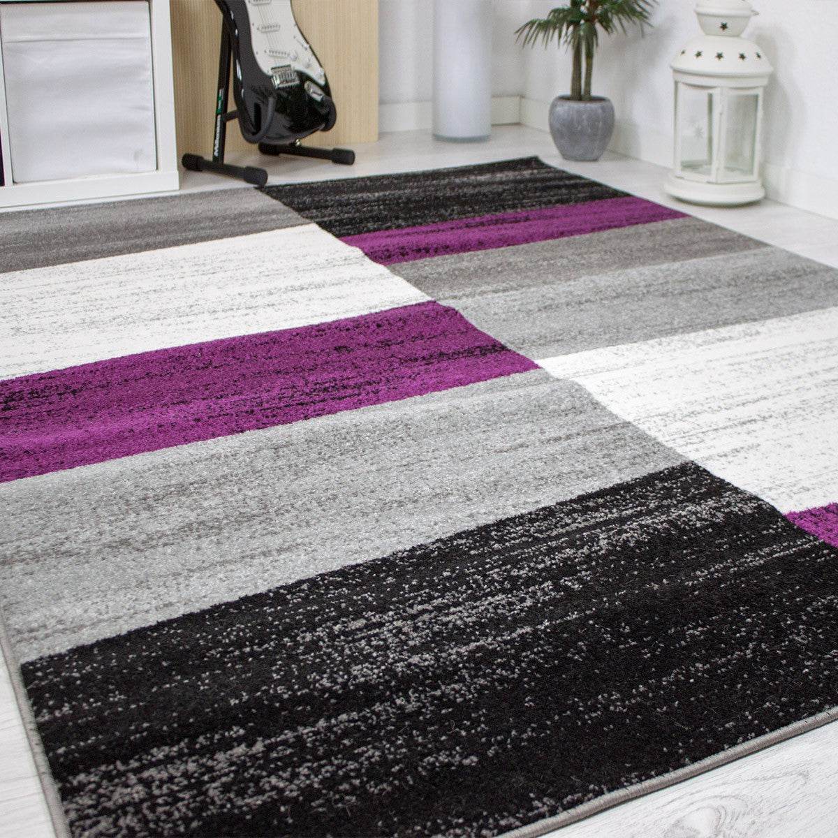 Rug with geometric tile pattern, mottled checkered in purple, grey, white and black